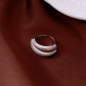 Dettaglio di anello aperto argento con trama a costine e zirconi molto brillanti.