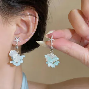 Vue détaillée des boucles d'oreilles fleur en cristal d'étoile de mer à glands bleus