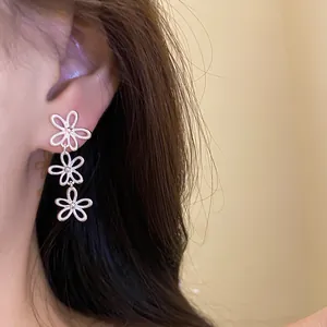 Silberne Hohlblumen-Ohrhänger am Modell getragen für einen eleganten minimalistischen Stil