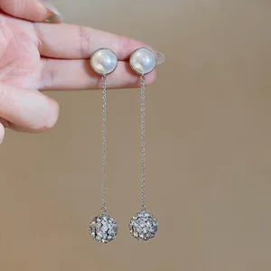 Detailed view of elegant silver drop earrings with round pearls and crystal pendants