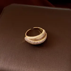 Primo piano di anello aperto placcato oro 14k con dettagli in pavé di zirconi