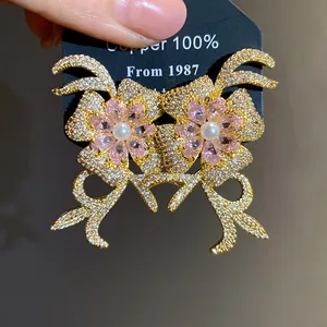 Detailed macro view of 18k gold plated zircon flower earrings with pearls