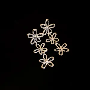 Detail von silbernen Hohlblüten-Ohrhängern mit fein strukturierten Blütenblättern.