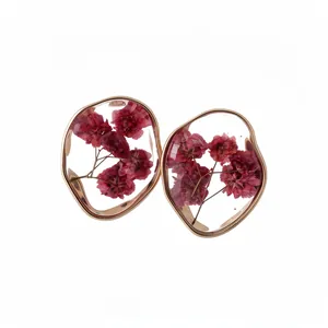 Irregular gold resin earrings featuring real dried red flowers for a romantic look