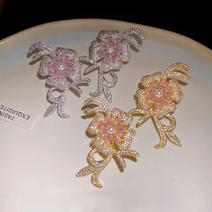 Detailed view of elegant zircon flower earrings featuring pearl centers and 18k gold plating