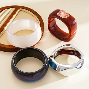 Variety of resin and metal bangles showing textures of rhinestone and galaxy patterns