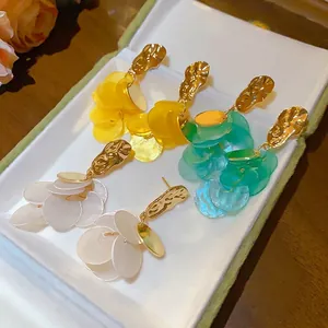Island vacation style shell tassel earrings with textured gold-tone studs