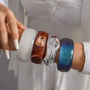 Detailed close-up view of assorted chunky resin and metallic bangles with rhinestone
