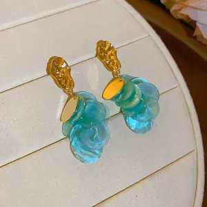 Close-up of island style shell tassel earrings with golden hammered studs