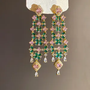 Exquisite close-up of 18k gold plated drop earrings with pink and green zircon floral motifs