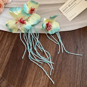 Handmade floral hair clips with long light blue beaded tassels in a romantic vacation style