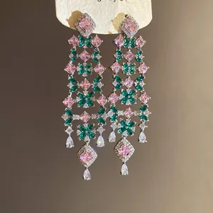 Elegant floral tassel earrings with sparkling pink and emerald green zircons in detail view.