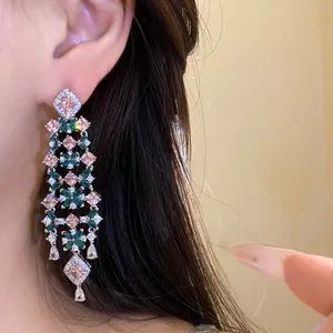 Detailed macro view of elegant floral tassel earrings featuring pink and green zircon stones