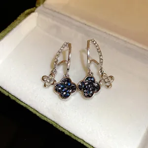 Close-up of sparkling flower-shaped stud earrings with blue crystals in a gift box