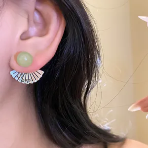 Detailed macro view showing the green resin bead and silver fan-shaped earring pendant