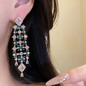 Detailed close-up of 18k gold plated floral tassel earrings with sparkling zircons.
