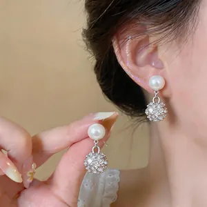 Dettaglio di eleganti orecchini di perle di lusso francesi con sfere di strass