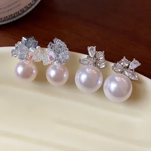 Elegant Korean-style zircon and pearl stud earrings presented on a cream display tray