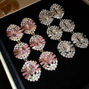 High-quality detailed view of elegant pink and clear crystal drop earrings on velvet