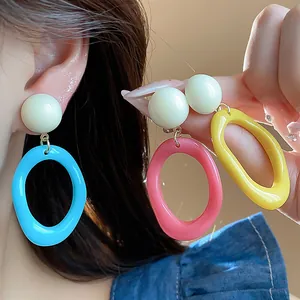 Close-up of vibrant colorful acrylic geometric hoop earrings for a stylish summer look.