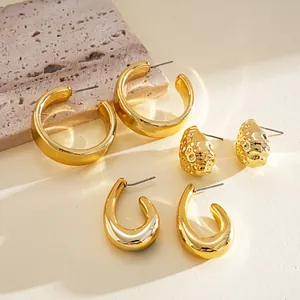 Close-up view of a six-piece gold earring set with C-shape hoops and textured studs