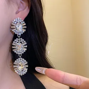 Elegant close-up view of triple-tiered oval rhinestone tassel earrings worn on ear