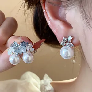 Close-up of elegant Korean style zirconia and pearl stud earrings with silver needles