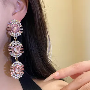 Detailed view of vintage-style dangling earrings with pink crystals and rhinestones