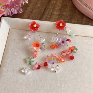 Vibrant dopamine style resin flower dangle earrings with silver needle posts.