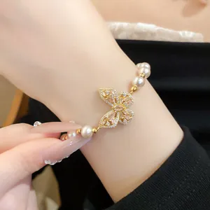 Gros plan de haute qualité d'un élégant bracelet de perles avec une breloque papillon en cristal