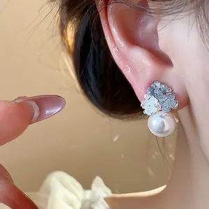 Close-up of elegant zircon and pearl stud earring worn on ear with soft lighting