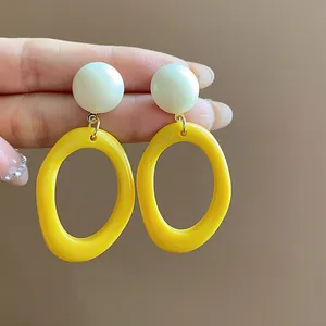 Vibrant yellow and white dopamine style acrylic geometric drop earrings detailed close-up view