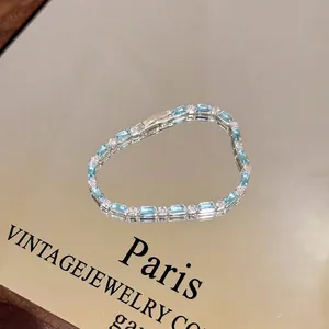 Macro view of a luxury silver bracelet featuring light blue baguette gemstones