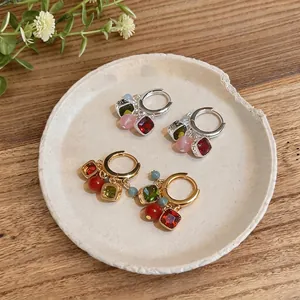 Orecchini a cerchio vintage con ciondoli colorati placcati oro e argento su un piatto
