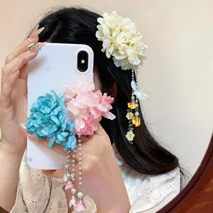Elegant fabric flower hair clip with long pearl tassels worn by a model in a sweet style