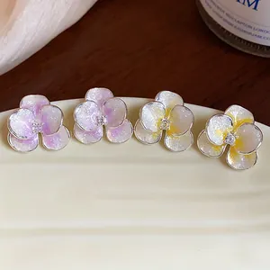 Detailed view of floral ear studs with glittering enamel petals and zircon centers.