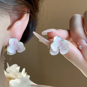 Close-up detail of silver iridescent enamel flower stud earrings with zircon center
