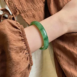 Elegant green chalcedony bangle shown on a wrist with a minimalist Chinese style.