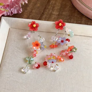 Close-up of colorful resin flower tassel earrings with vibrant dopamine style