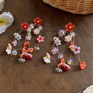 Exquisite detailed view of colorful resin flower tassel earrings on a wooden surface.