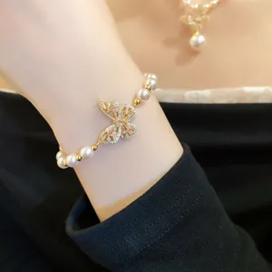 Gros plan d'un élégant bracelet en perles avec un papillon en zircone scintillant