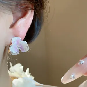 Close-up detail of a silver needle flower stud earring with pearlescent enamel petals.