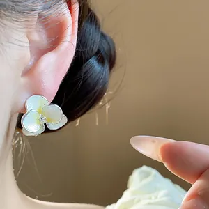 Macro view of elegant white and yellow flower stud earring with a zircon center