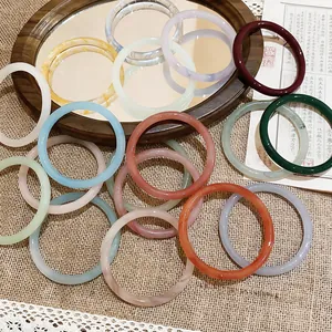 A collection of colorful chalcedony bangles arranged artistically on a vintage background.