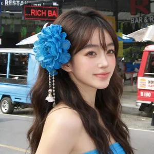 Close-up of a blue fabric flower hair clip with pearl tassels worn by a model