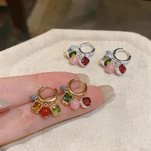 Vista dettagliata di orecchini a cerchio vintage con ciondoli in pietre multicolore