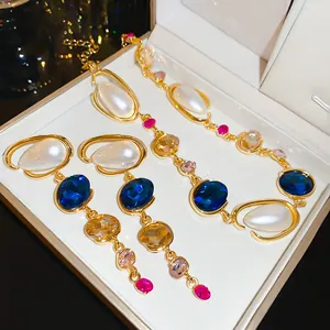 Elegant detail of a geometric jewelry set featuring white pearls and blue crystals