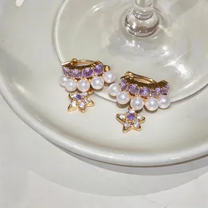 Eleganti orecchini a cerchio con stelle in zircone, pietre viola e perle bianche.