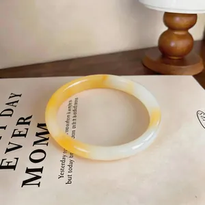 Close-up detail of a minimalist yellow and white gradient chalcedony bangle bracelet