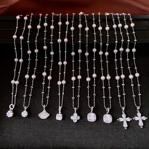 Eleganti collane in zircone e perle argentate con vari ciondoli su velluto nero di lusso